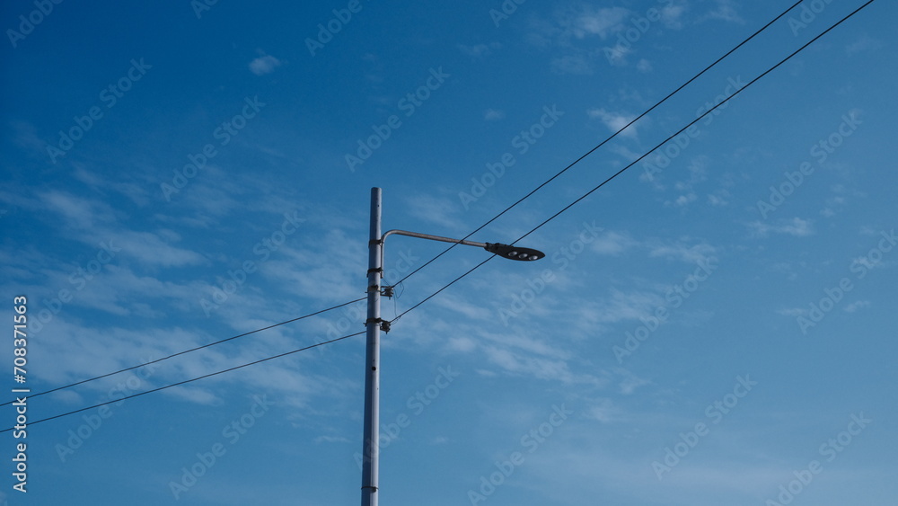 Street lamp and the beautiful blue sky in the background , visible cables Street lamp and the beautiful blue sky in the background , visible cables