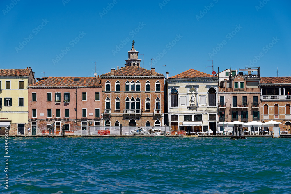 Old town of Italian City of Venice with colorful facades of historic houses and church tower seen from Canale san Giorgio on a sunny summer day. Photo taken August 7th, 2023, Venice, Italy.