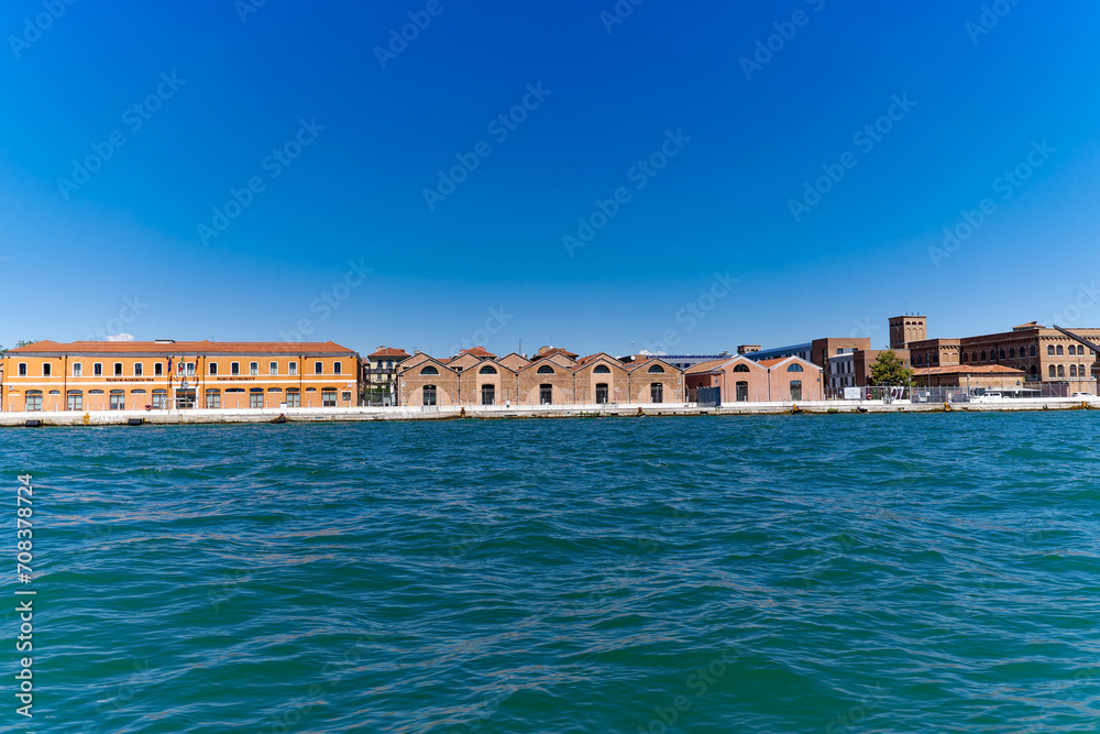 Scenic view of San Giorgio Canal with storage buildings in the background at Italian City of Venice on a sunny summer day. Photo taken August 7th, 2023, Venice, Italy.