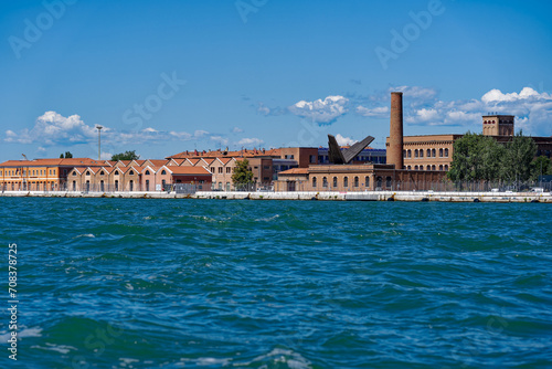 Scenic view of San Giorgio Canal with storage buildings in the background at Italian City of Venice on a sunny summer day. Photo taken August 7th, 2023, Venice, Italy.