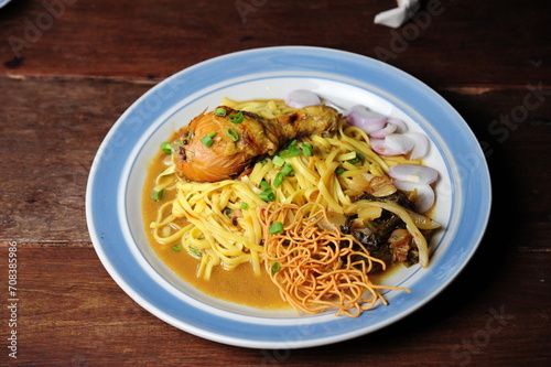 Northern food chicken khao soi in a bowl on a wooden table