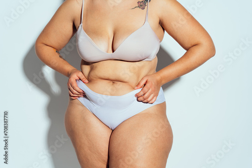 Plus size woman posing in studio in lingerie