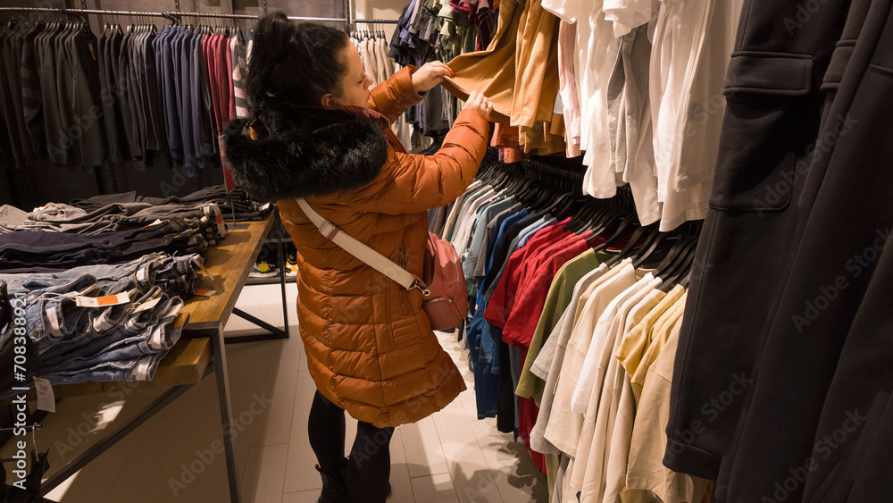 Fototapeta premium Woman looking for new clothes in the store.