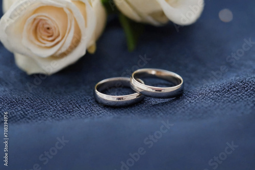 Two simple wedding rings resting on a precious dark blue fabric
