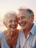 An elderly couple laughs together happily in a field of beautiful colorful flowers at sunset.