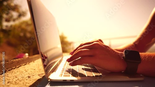 Woman laptop sea. Working remotely on seashore. Happy successful woman female freelancer working on laptop by the sea at sunset, makes a business transaction online. Freelance, remote work on vacation photo
