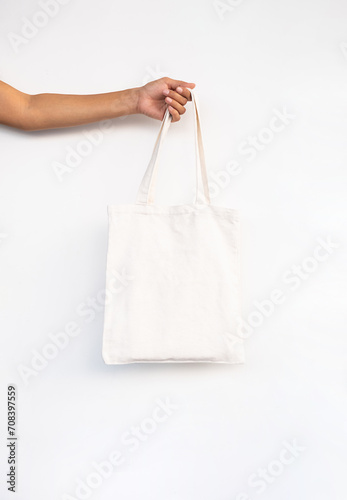 Females hand holding reusable textile shopping bag.