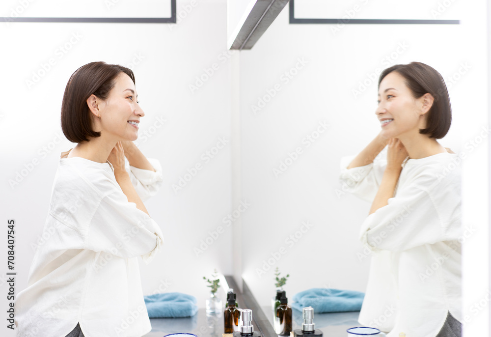 鏡を見ながら髪を触っている女性/ヘアケア 鏡を見ながら髪を触っている女性/ヘアケア
