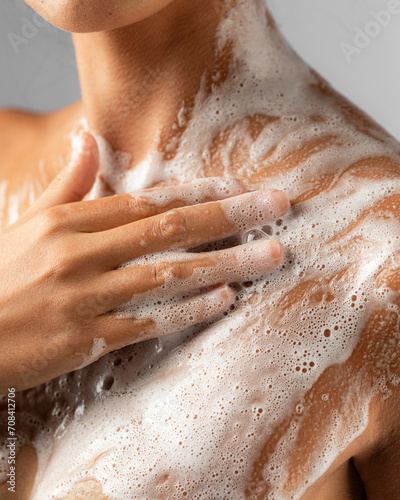 Woman washing soaped her body with a foam