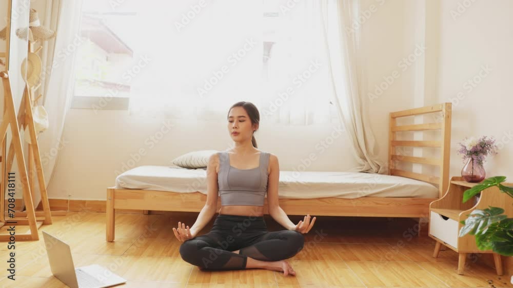 Beautiful happy girl with closed eyes practicing yoga in lotus position in bedroom in the mornin Beautiful happy girl with closed eyes practicing yoga in lotus position in bedroom in the mornin