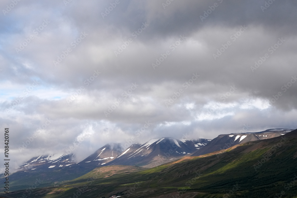 Wolkenumhängte Bergehänge bei Akureyri in Island