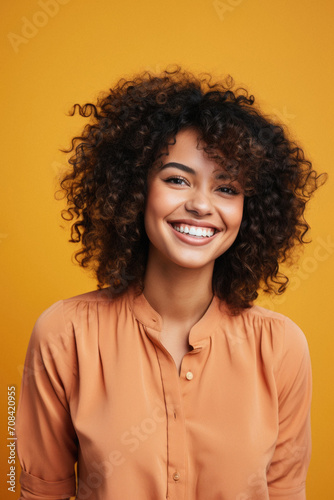 Portrait of a beautiful young african american woman smiling and looking at camera isolated over yellow background