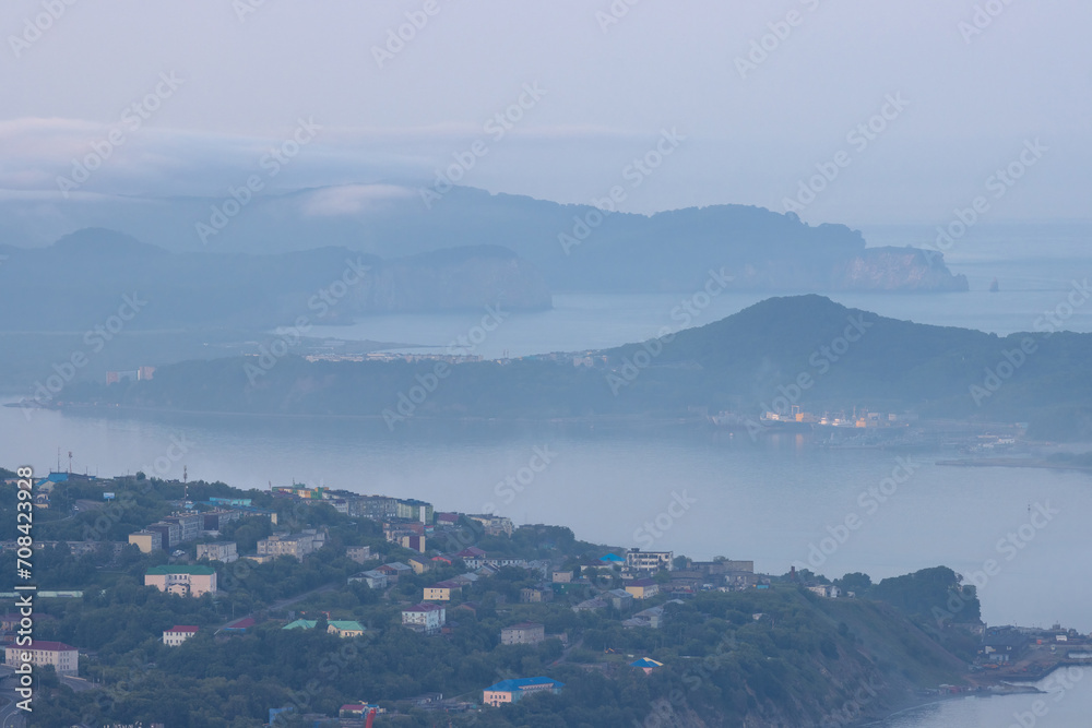 Morning landscape. Aerial view of the port town on the coast of the bay. Top view of buildings and hills. Avacha Bay, Pacific Ocean. Petropavlovsk-Kamchatsky, Kamchatka Krai, Far East of Russia.
