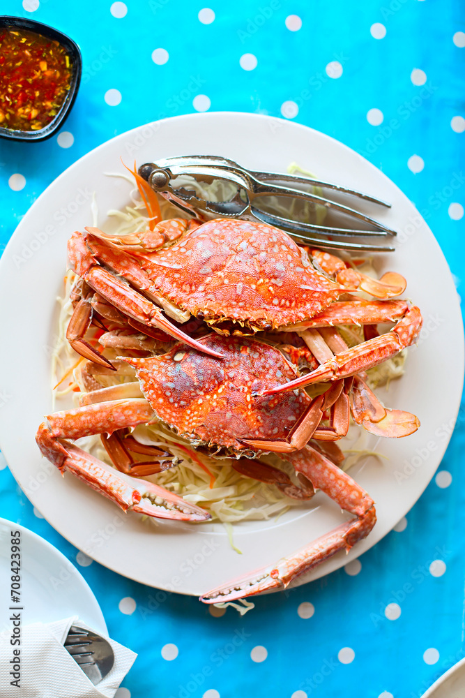 Two freshly cooked crabs on the white plate serviced with white cabbage Two freshly cooked crabs on the white plate serviced with white cabbage