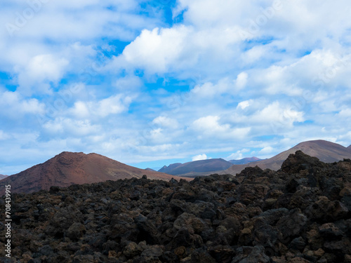 Spectacular view of the Fire Mountains at Timanfaya National Park, this unique area consisting entirely of volcanic soils. Volcanic landscape in a sea of ​​lava. Plenty space of text. Lanzarote, Spain