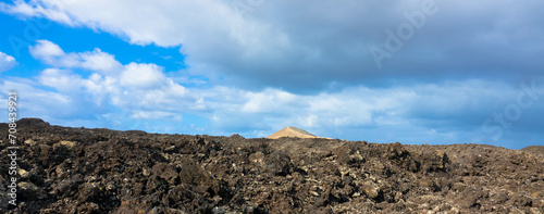 Spectacular view of the Fire Mountains at Timanfaya National Park, this unique area consisting entirely of volcanic soils. Volcanic landscape in a sea of ​​lava. Plenty space of text. Lanzarote, Spain