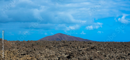 Spectacular view of the Fire Mountains at Timanfaya National Park, this unique area consisting entirely of volcanic soils. Volcanic landscape in a sea of ​​lava. Plenty space of text. Lanzarote, Spain
