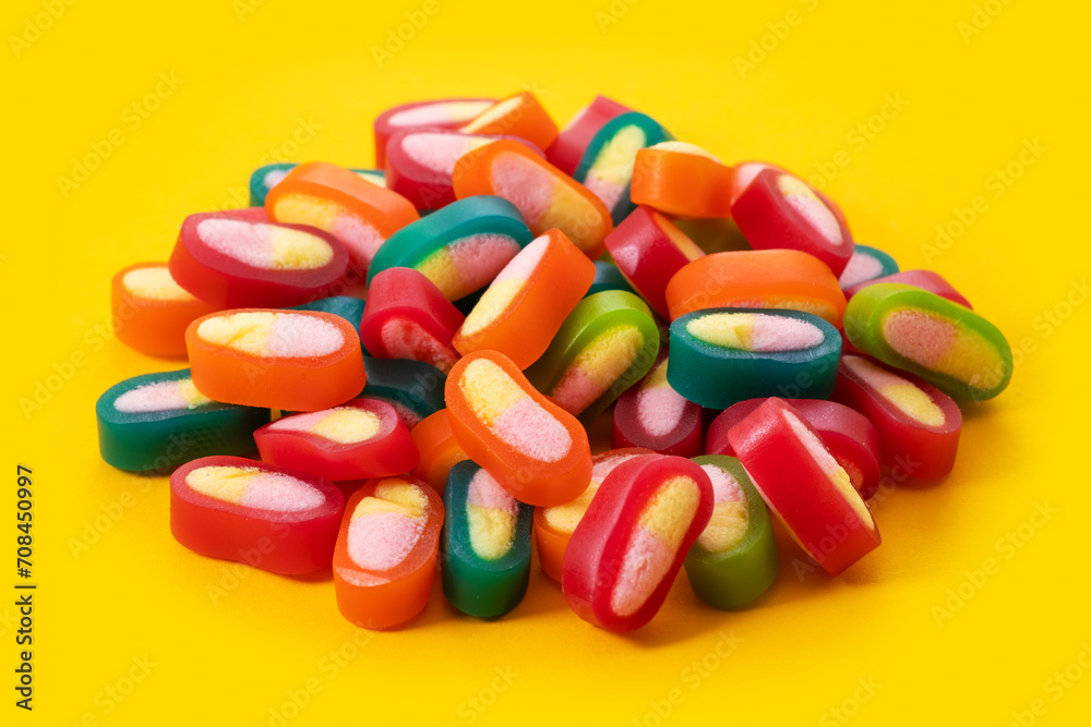 Piles of delicious colorful jelly candies on yellow background Piles of delicious colorful jelly candies on yellow background