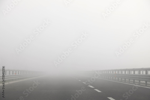 lane of motorway without cars but with a lot of dangerous fog photo