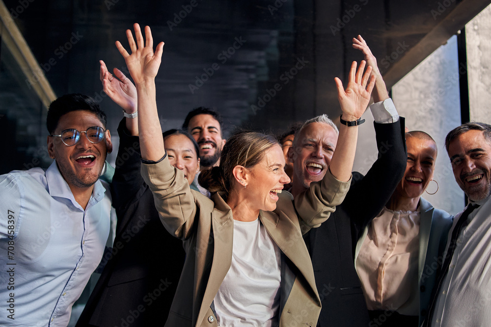 Diverse multiracial cheerful group of excited business people standing in office hallway having fun. Joyful colleagues celebrating success by raising hands at same time and smiling happy together - obrazy, fototapety, plakaty 