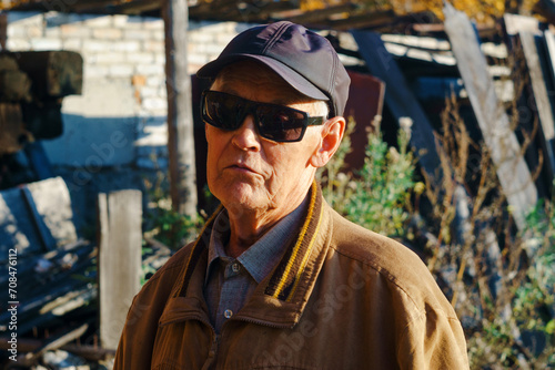 One modern senior Caucasian man wearing sun protection glasses portrait of male grandfather with beard and hat cap. © Алексей Филатов