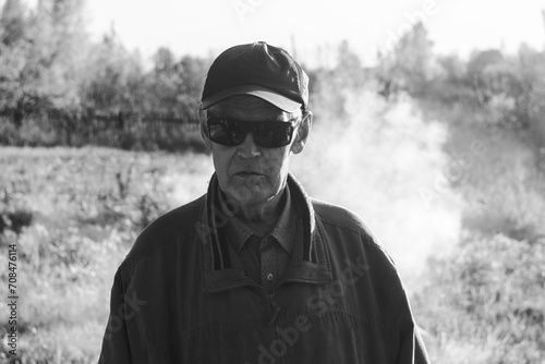 One modern senior Caucasian man wearing sun protection glasses portrait of male grandfather with beard, Black and white photo © Алексей Филатов