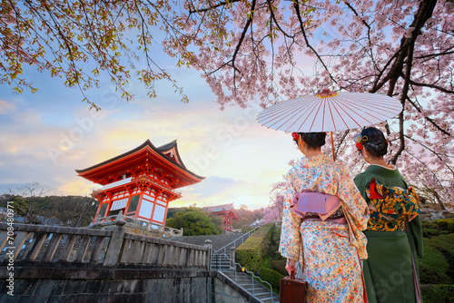Scenic view of Young Japanese women in a traditional Kimono dress at Kiyomizu-dera temple sunrise during full bloom cherry blossom in Kyoto, Japan
