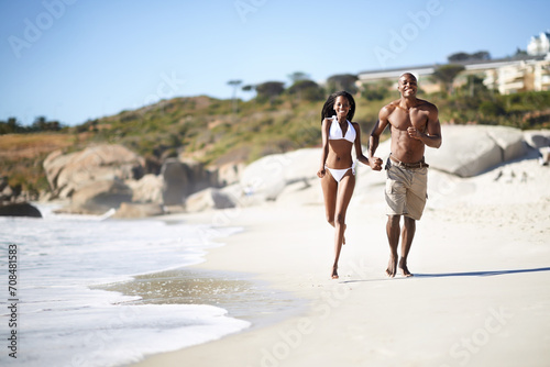 Happy couple, running on beach and hand holding with smile and married on holiday, outdoor and bikini. Vacation, travel or love for commitment, bonding together and care for romantic relationship