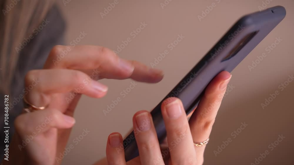 Close-up of female hands with manicure, using smartphone to check email for work or sending SMS text message at home, online communication concept. Reading blog, article, or post. Camera