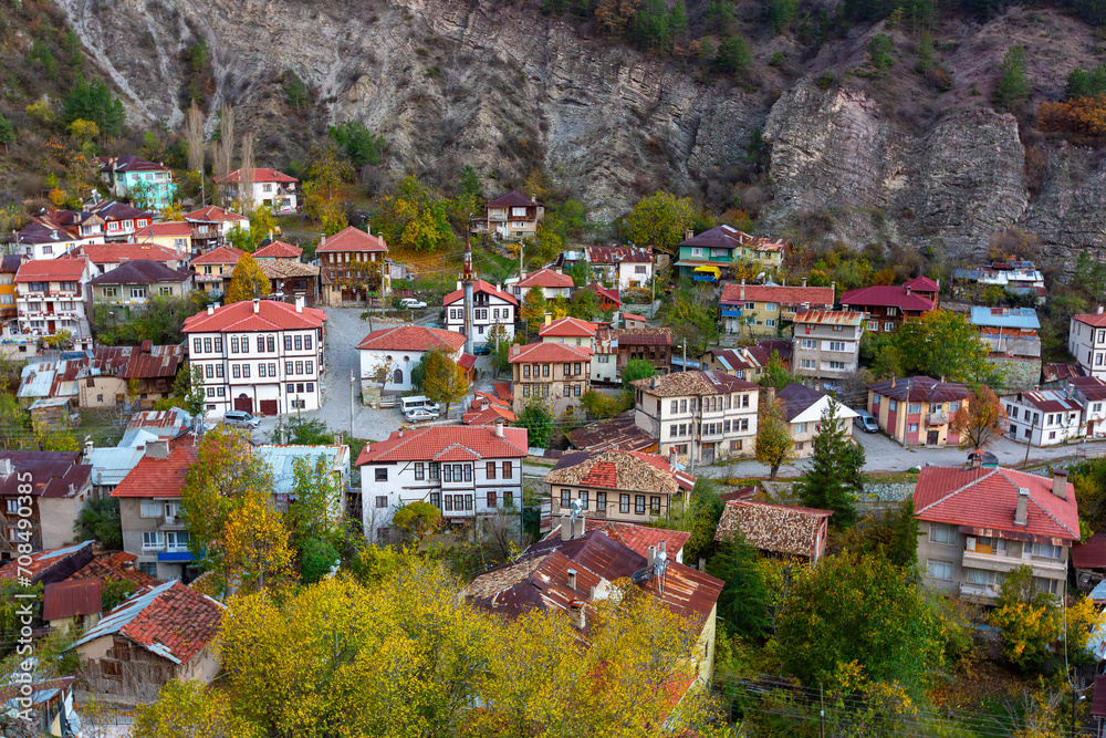 Historical old white small wooden houses of Mudurnu among mountains and trees.