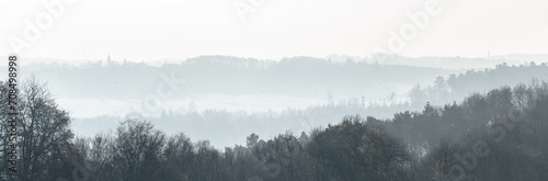 Panorama of a foggy forest landscape in the rural countryside during winter in Germany, Europe © MikeCS images