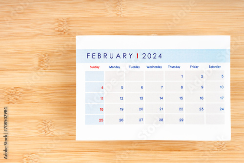 February 2024 calendar page on wooden background.