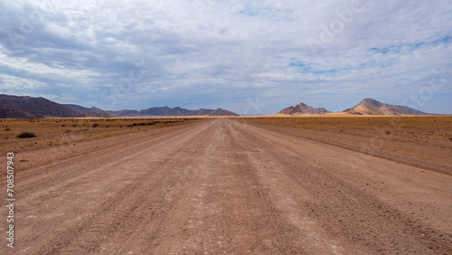 Driving along a long gravel road straight inside Namibia