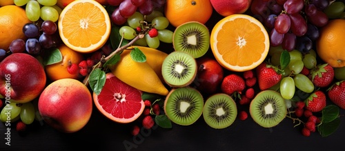 An assortment of juicy fruits including kiwi  orange  apple  grapes  and grapefruit.