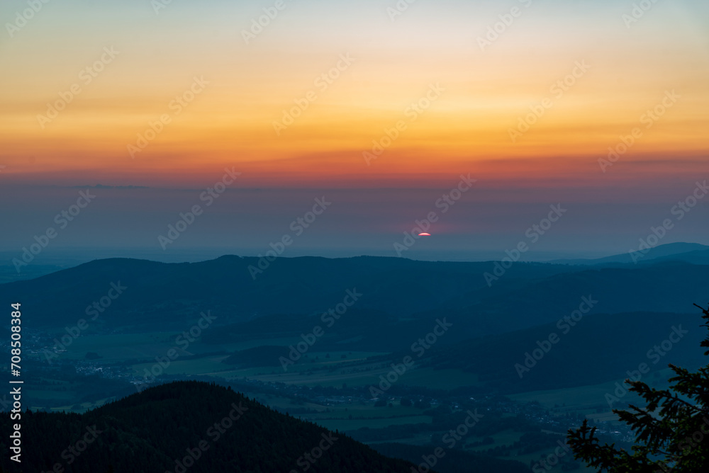 Sunrise from Cervena hora hill in Jeseniky mountains in Czech clouds