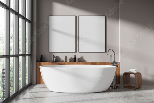 Beige bathroom interior with tub and posters