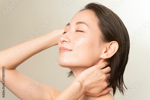 ヘアケアをしている女性/艶肌で髪が濡れている/40代日本人女性のビューティーポートレート photo