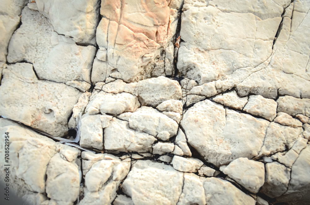 Fototapeta premium Texture of mountain rock on a sunny day, background. Lines and spots. Antibes, France