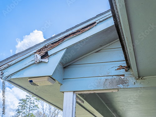 Distressed roofline of a house in need of repair because of dry rot and black mold from years of neglect.