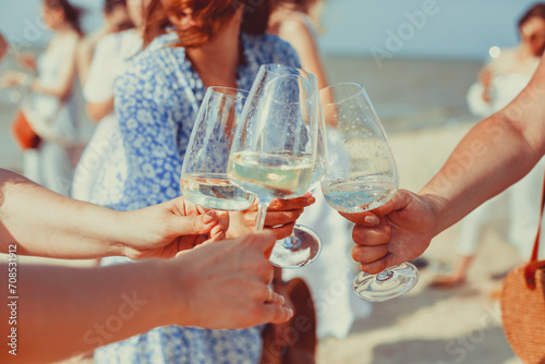 Cheerful women proposing toast on beach