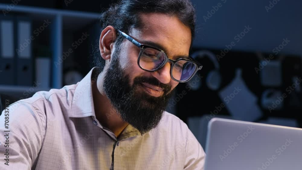 Smiling Indian businessman, clad in professional attire, is actively engaged in work. The harmonious combination of positive demeanor and focused effort creates an atmosphere of productivity. Smiling Indian businessman, clad in professional attire, is actively engaged in work. The harmonious combination of positive demeanor and focused effort creates an atmosphere of productivity.