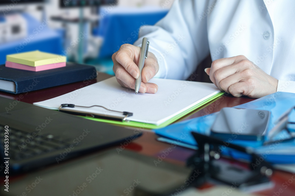The doctor makes a note in a blank document . The doctor makes a note in a blank document .