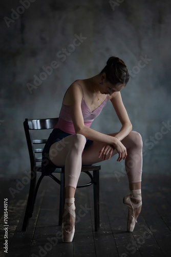 Portrait of a ballerina sitting on a chair.