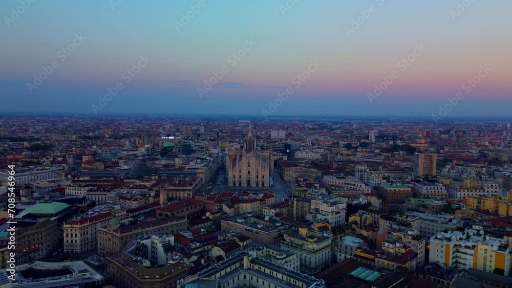 Aerial view of the statue of the Madonna on the central spire of the duomo and the city's cathedral at dawn. Roofs of houses and skyscrapers. Sun over the horizon. duomo square. Italy, Milan, 2024 Aerial view of the statue of the Madonna on the central spire of the duomo and the city's cathedral at dawn. Roofs of houses and skyscrapers. Sun over the horizon. duomo square. Italy, Milan, 2024