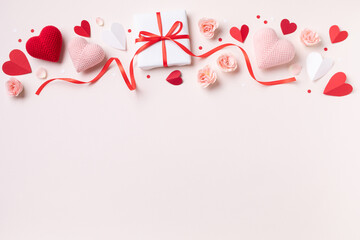 Valentine day or mother day festive composition with gift or present box, rose flowers and red pink hearts on pastel background top view. Flat lay greeting card..