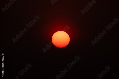 Big red sun isolated in black background in the evening