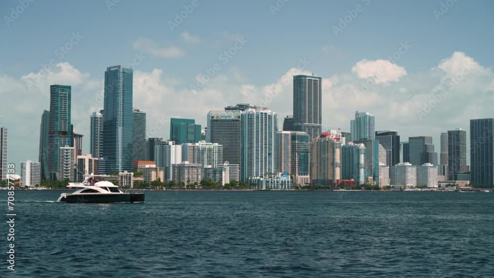 Yachts sailing in Miami Florida, USA. American downtown office district. High commercial and residential skyscraper buildings in modern US megapolis. Yachts sailing in Miami Florida, USA. American downtown office district. High commercial and residential skyscraper buildings in modern US megapolis.