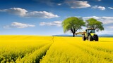 Cultivated landscape in spring, blooming rapeseed field, tractor with field sprayer in the background