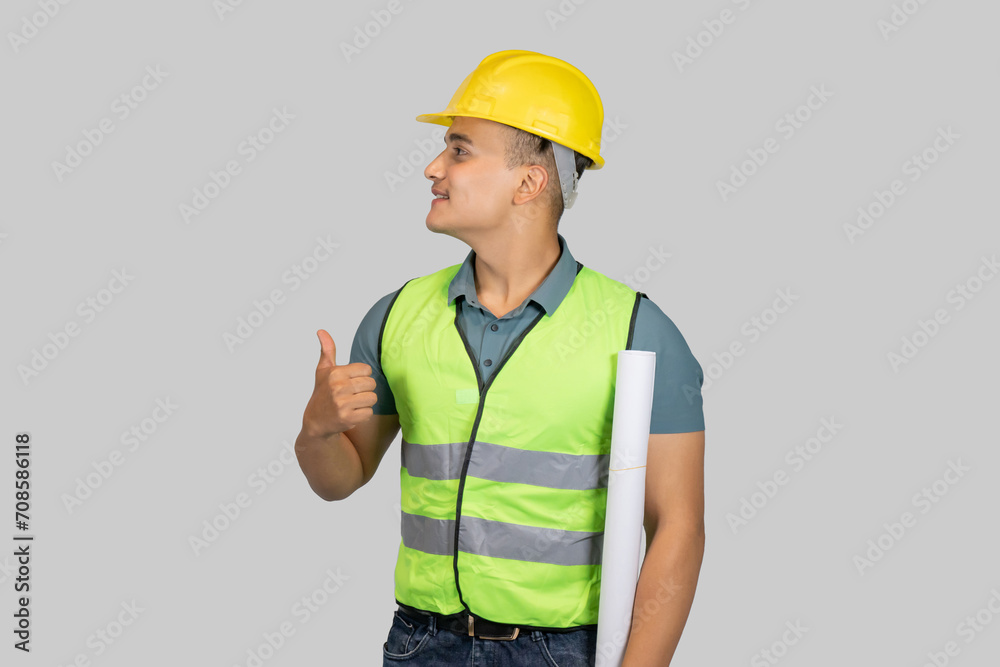 An Asian Happy Construction Worker Engineer giving expression gestures with chartpaper and notebook An Asian Happy Construction Worker Engineer giving expression gestures with chartpaper and notebook