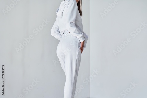 Experience the Ultimate in Casual Style with this Contemporary White Ensemble. Sportwear mock-up. Girl in white pants. Back view of a young woman wearing white minimalist sweatpants.